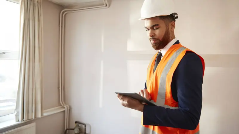 Gas safety engineer in high visibility jacket carrying out landlord checks Wolverhampton